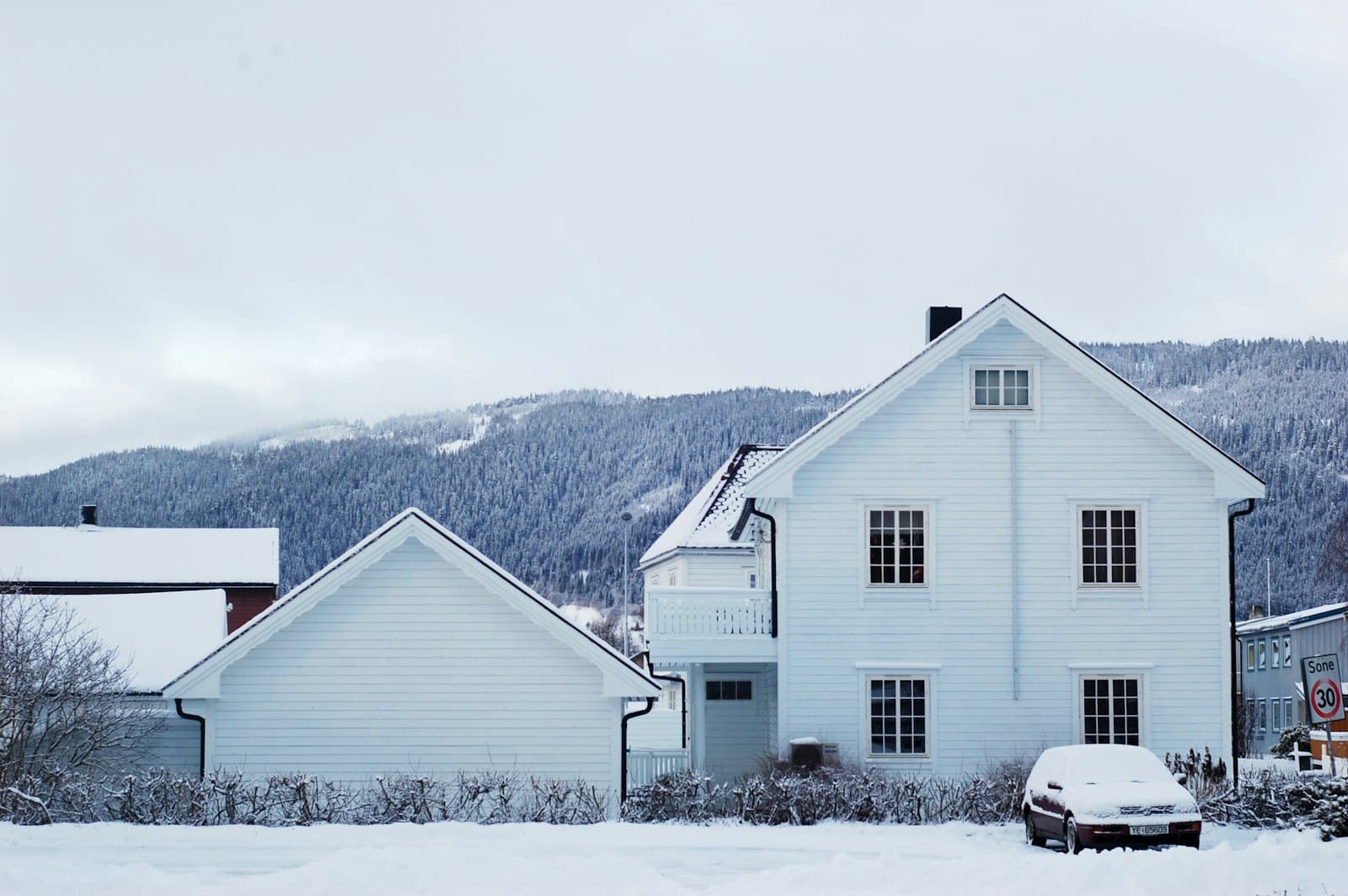 Vit träklädd villa i nordiskt vinterlandskap
